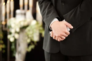 Close up of folded hands at funeral service